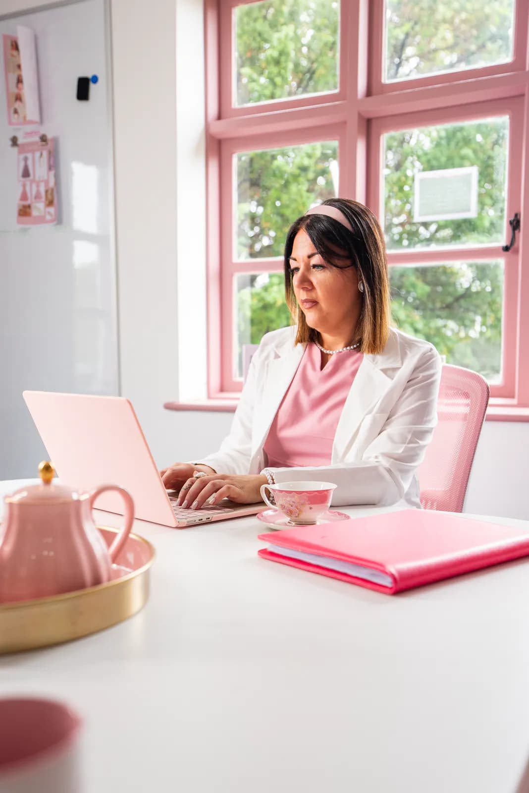 An academy team member preparing written course information beside a pink folder.