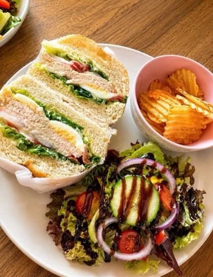 A Blossom Stack sandwich served with salad and crisps
