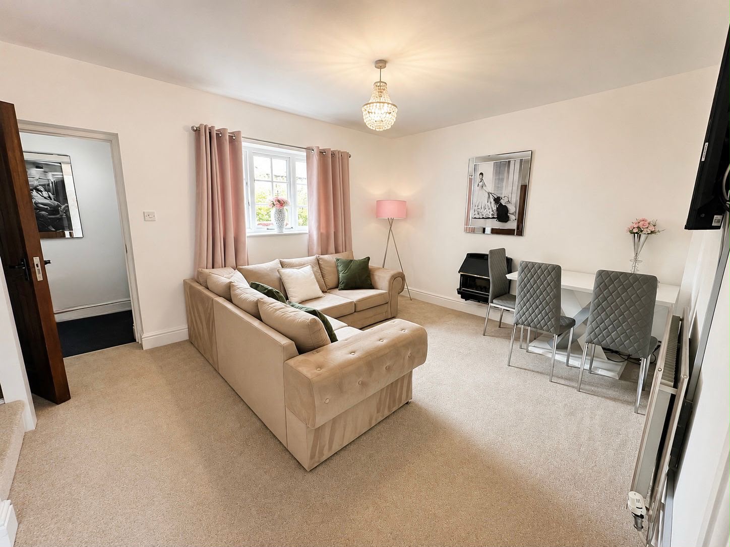 The far end of the sitting room, with a dining table and four chairs beside the window